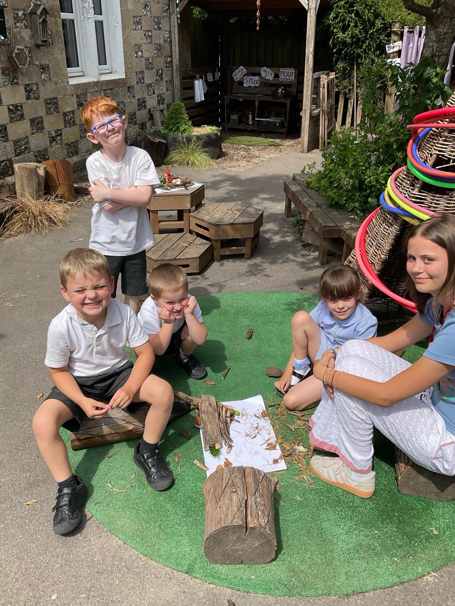 A group of KS1 pupils sit outside the classroom together.